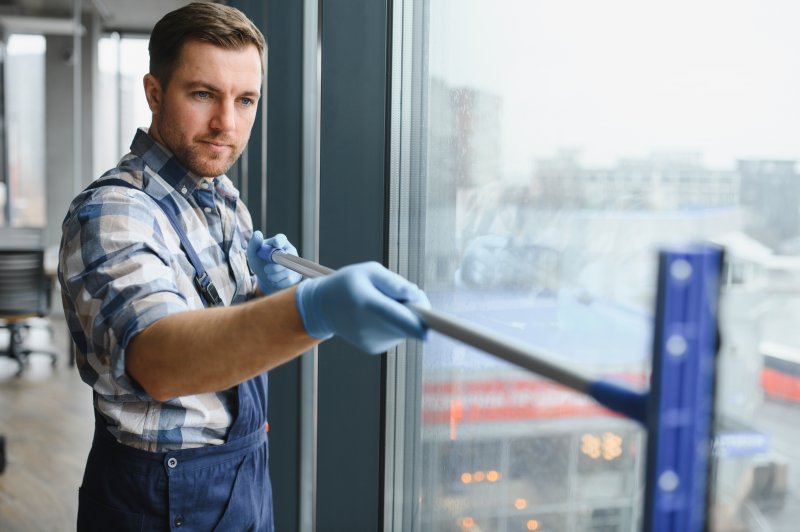 a commercial cleaner wiping windows clean